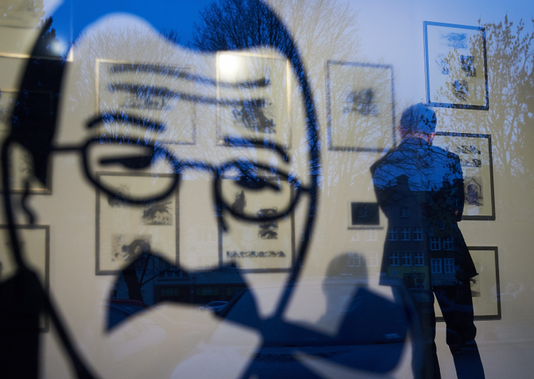 Akwaforty "Psie lata" (w tle) Guentera Grassa, eksponowane na wystawie „Guenter Grass. Kolekcja Plus”, przygotowanej w pierwszą rocznicę śmierci noblisty w Gdańskiej Galerii Guentera Grassa w 2016 r. Fot. PAP/Adam Warżawa