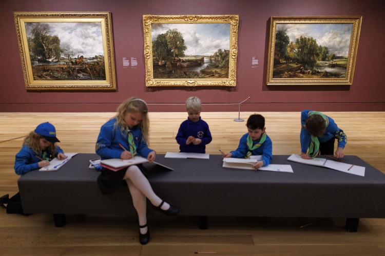 Uczniowie szkicują obrazy Johna Constable'a „Skaczący koń” (z lewej), „Widok na Stour koło Dedham” (w środku) i „Biały koń” (z prawej) podczas otwarcia wystawy „Turner i Constable: rywale i oryginały” w Tate Britain. Fot. PAP/EPA/Tolga Akmen