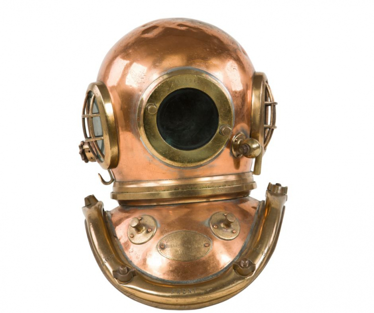 Hełm nurkowy Siebe-Gorman 6-bolcowy z kołnierzem. Na przedniej płaszczyźnie kołnierza widoczne bolce do zawieszania zaczepów od ciężarków. Poniżej tabliczka znamionowa z nazwą producenta Siebe-Gorman & Company Ltd. Elementy zestawu nurkowego Siebe-Gorman. Fot. P. Jóźwiak | Zbiory NMM