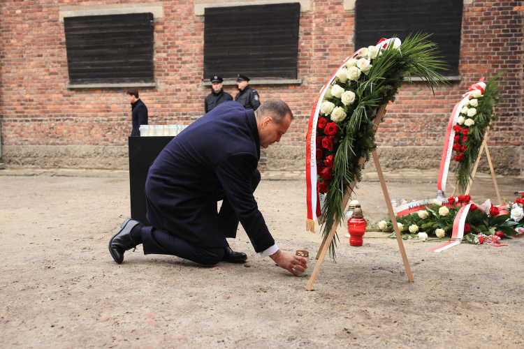 Prezydent Karol Nawrocki podczas uroczystości złożenia kwiatów przed Ścianą Śmierci na terenie byłego obozu Auschwitz w Oświęcimiu. Fot. PAP/Jarek Praszkiewicz
