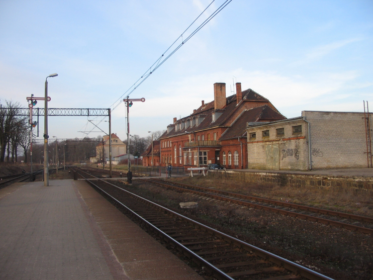 Stacja kolejowa w Pasłęku, widok na peron i budynek dworcowy, zdjęcie z lutego 2008 r. Fot. Krzysztof Maria Różański, (Upior polnocy), CC BY-SA 3.0 <https://creativecommons.org/licenses/by-sa/3.0>, via Wikimedia Commons