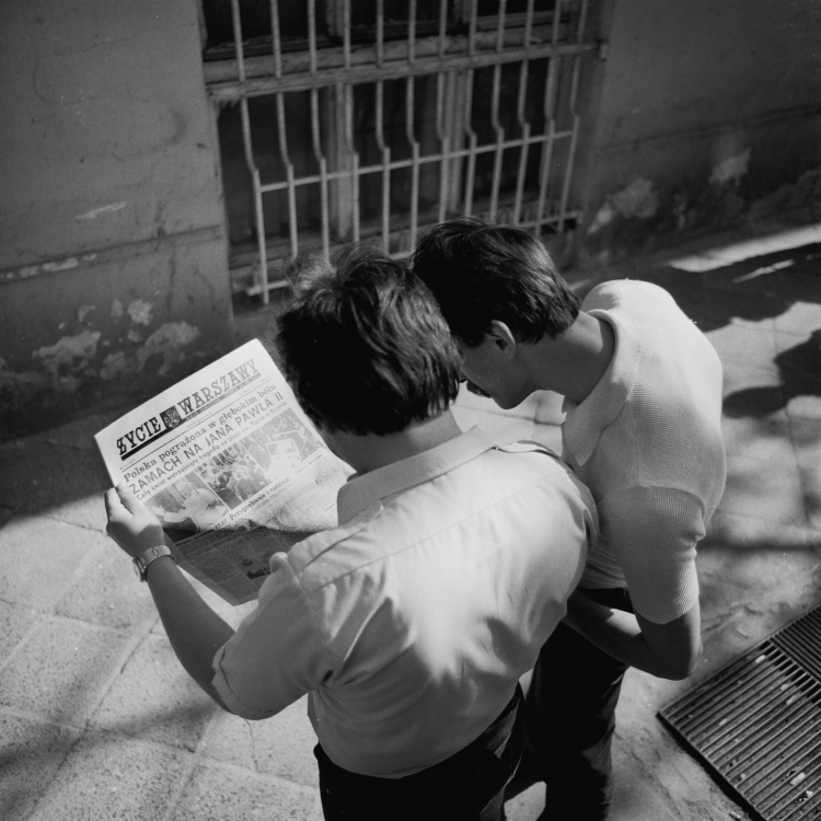 Warszawa, maj 1981. Mężczyźni czytają dziennik "Życie Warszawy" (wyd. z 14 maja 1981 r.), informujący na pierwszej stronie o zamachu na życie papieża Jana Pawła II, do którego doszło 13 maja na placu św. Piotra w Rzymie. Fot. PAP/Afa Pixx/Zenon Żyburtowicz