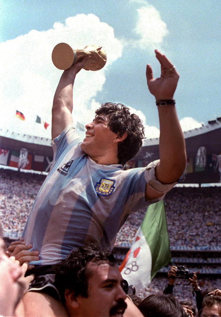 Diego Maradona unosi trofeum Mistrzostw Świata po zwycięstwie Argentyny w Mistrzostwach Świata w Meksyku w 1986 roku. Fot. PAP/EPA