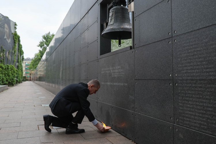 Dziennikarz i działacz mniejszości polskiej na Białorusi Andrzej Poczobut zapala znicz przed dzwonem „Monter” podczas wizyty w Muzeum Powstania Warszawskiego w Warszawie, 19 bm. Fot. PAP/Paweł Supernak