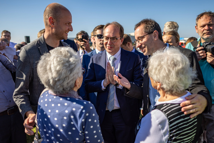 Niemiecki minister spraw wewnętrznych Alexander Dobrindt (w środku) wita Milenę Grenfell-Baines i Evę Paddock, obie spośród dzieci uratowanych przez Sir Nicholasa Wintona przed II wojną światową, podczas uroczystości upamiętniających ofiary wypędzenia przy zbiorowej mogile w ramach Marszu Pojednania w Pohorelicach w Czechach, 23 maja 2026 r. Fot. EPA/MARTIN DIVISEK Strona: PAP/EPA