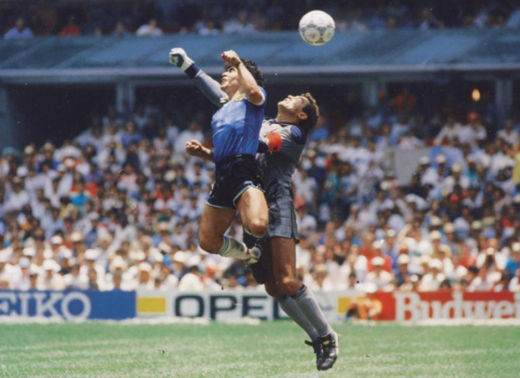 Legendarny argentyński piłkarz Diego Maradona mawiał, że „trochę ręka Boga” odpowiadała za gol, który strzelił Anglii 22 czerwca 1986 r. podczas ćwierćfinału mundialu. Ten uznany przez sędziego nieprawidłowy strzał to w historii sportu ikoniczny przykład oszustwa. Fot. El Gráfico, Public domain, via Wikimedia Commons
