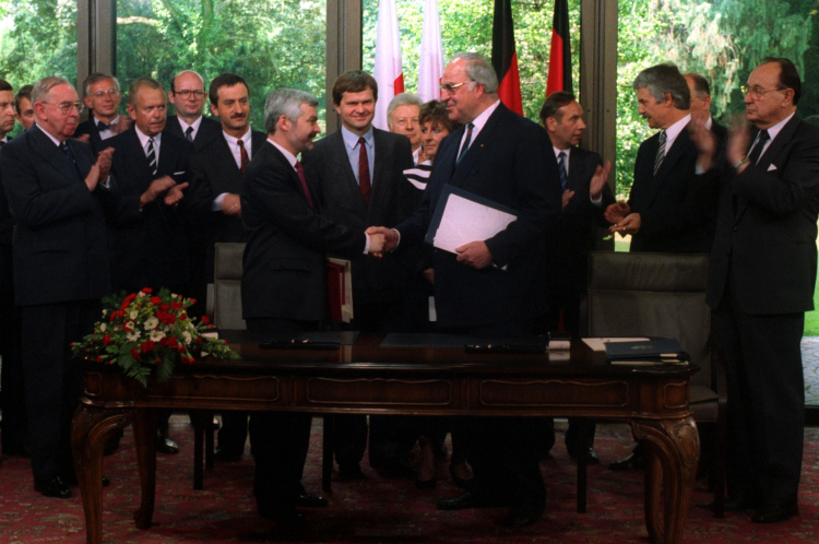 Niemcy, Bonn, 1991-06-17. Podpisanie traktatu między Rzecząpospolitą Polską a Republiką Federalną Niemiec o dobrym sąsiedztwie i przyjaznej współpracy. Nz. premier RP Jan Krzysztof Bielecki (L) i Kanclerz Niemiec Helmut Kohl wymieniają uścisk dłoni po podpisaniu dokumentu. Wśród polityków m.in. Bogusław Marczewski (1L), Piotr Ogonowski (2L częściowo zasłonięty), minister spraw zagranicznych Polski Krzysztof Skubiszewski (3L), szef polskiego protokołu dyplomatycznego Janusz Świtkowski (5L), polski dyplomata 