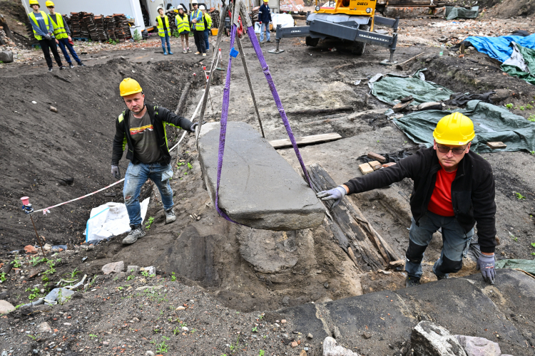 Gdańsk, 7.07.2026 r. Płyta nagrobna z reliefem krzyża łacińskiego z XIII wieku w Gdańsku. Archeolodzy natrafili na artefakt w trakcie wykopalisk prowadzonych u zbiegu ulic Grodzkiej i Sukienniczej. Fot. PAP/Marcin Gadomski