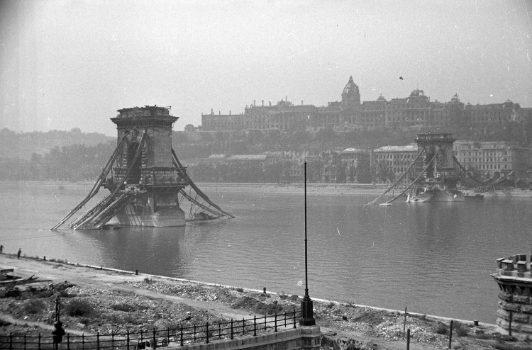 Wypalone ruiny Zamku Królewskiego z widokiem na zniszczony Most Łańcuchowy w Budapeszcie, 1945 r. Fot. FOTO:FORTEPAN / Kurutz Márton, CC BY-SA 3.0 <https://creativecommons.org/licenses/by-sa/3.0>, via Wikimedia Commons