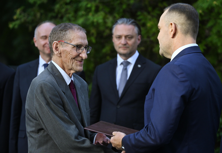 Syn podporucznika Sergiusza Piaseckiego prof. Władysław Tomaszewicz (L) odbiera akt pośmiertnego mianowania ojca na stopień kapitana Wojska Polskiego z rąk prezydenta RP Karola Nawrockiego (2P) oraz wicepremiera, ministra obrony narodowej Władysława Kosiniaka-Kamysza (P) podczas Apelu Pamięci przed Pomnikiem Poległych w 1920 r. na Cmentarzu Wojskowym na Powązkach w Warszawie, 14 bm. Uroczystość odbywa się w ramach obchodów Święta Wojska Polskiego. Fot. PAP/Piotr Nowak