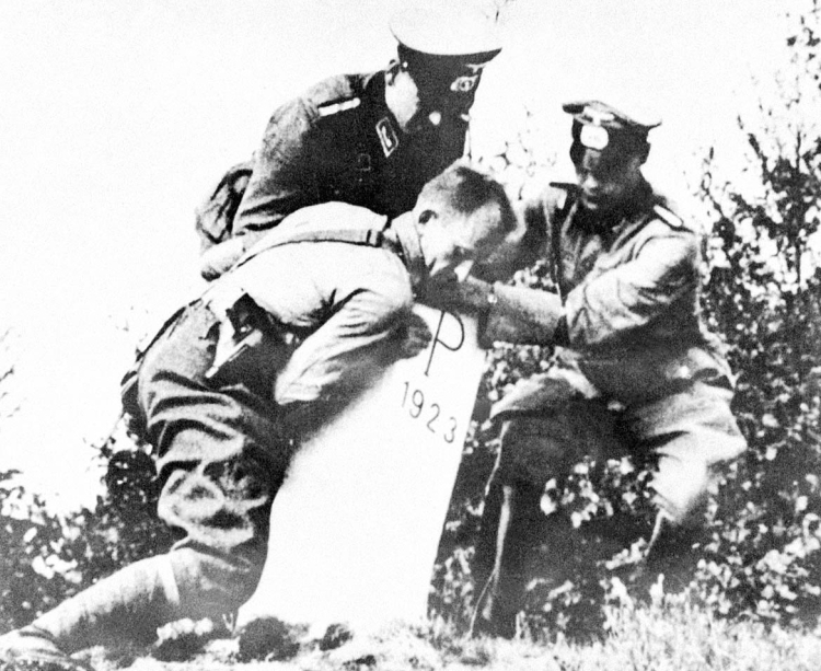 Reprodukcja: inwazja Niemiec na Polskę we wrześniu 1939 r., żołnierze niemieccy obalają słup graniczny. Fot. PAP/Reprodukcja