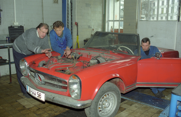 Jacek Borkowski (2L) w warsztacie samochodowym Mercedesa przy ul. Mińskiej. Aktor jest pasjonatem starych aut, bierze udział w remoncie Mercedesa 220 SE Cabrio z roku 1963. Fot. PAP/Maciej Billewicz